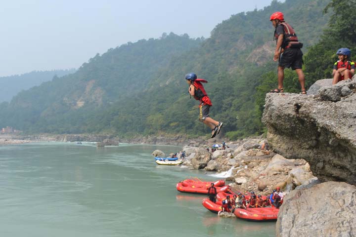 Woodstock students jump into a river during activity week